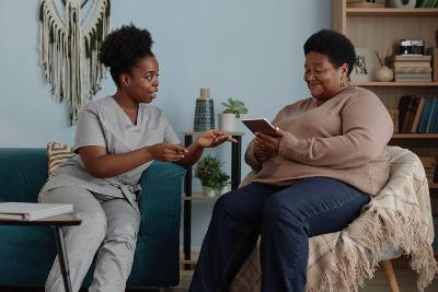 An older woman and a woman care worker sitting together