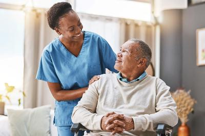 A carer chatting to an older man in a wheelchair